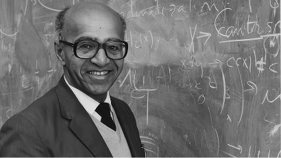 David Blackwell smiling in front of a chalkboard covered with mathematical equations